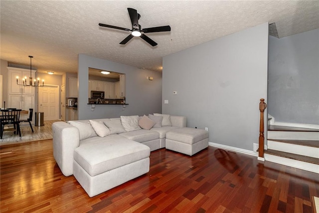 8601 Flint Hill Rd, Douglasville, GA 30135 - living room with wood finished floors, a chandelier, ceiling fan, a textured ceiling, and baseboards