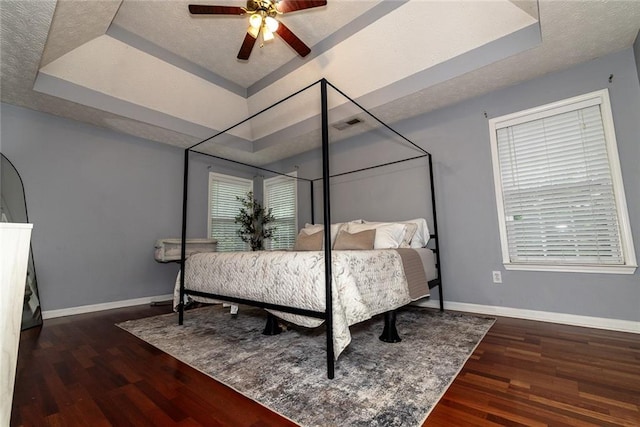 8601 Flint Hill Rd, Douglasville, GA 30135 - bedroom featuring a tray ceiling, wood finished floors, baseboards, a textured ceiling, and a ceiling fan