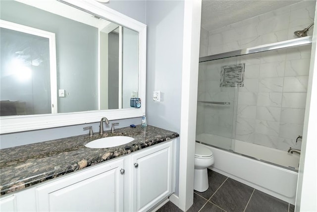 8601 Flint Hill Rd, Douglasville, GA 30135 - bathroom featuring vanity, toilet, combined bath / shower with glass door, tile patterned flooring, and a textured ceiling