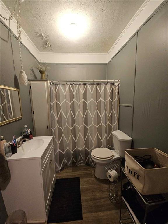 bathroom with vanity, ornamental molding, a textured ceiling, hardwood / wood-style flooring, and toilet