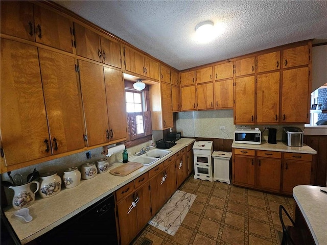 kitchen with dishwasher, a textured ceiling, and sink