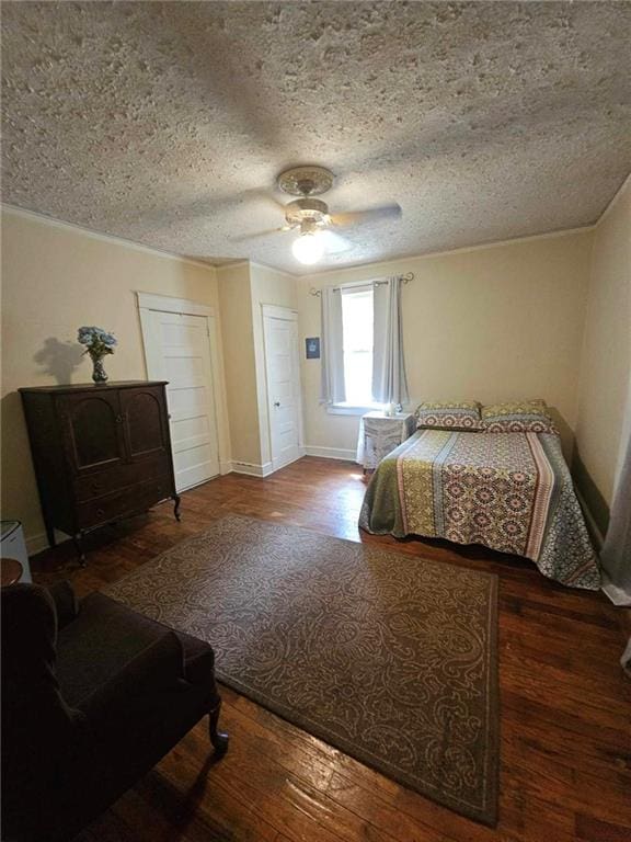 bedroom with ceiling fan, dark hardwood / wood-style floors, and a textured ceiling