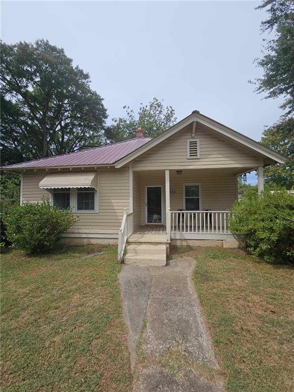 view of front of house with a front yard and a porch