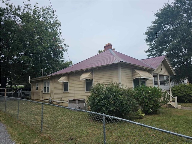 view of property exterior featuring a lawn and central AC unit