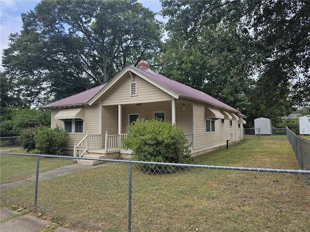 bungalow-style home with a shed, a front lawn, and covered porch