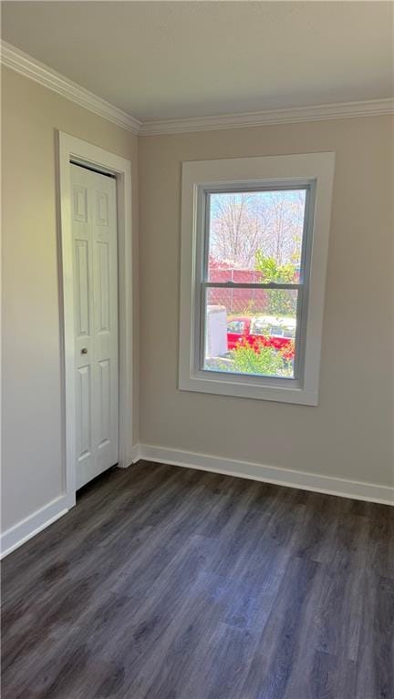 unfurnished bedroom with crown molding, baseboards, and dark wood-style flooring