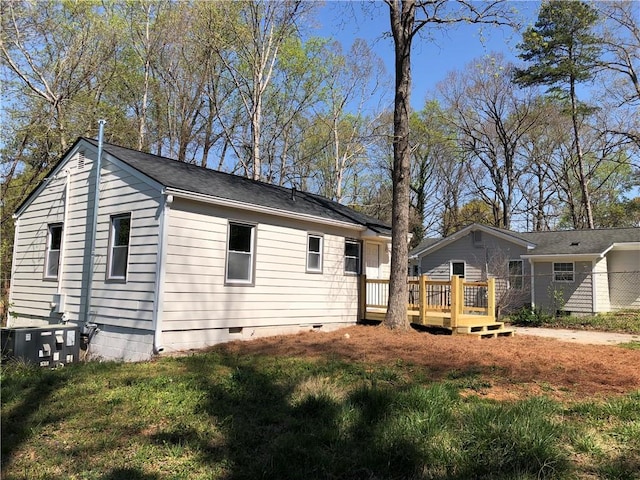 back of property with a lawn, a deck, central AC, and crawl space
