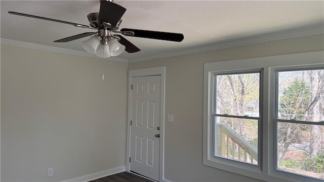 foyer with dark wood-style flooring, baseboards, ornamental molding, and a healthy amount of sunlight