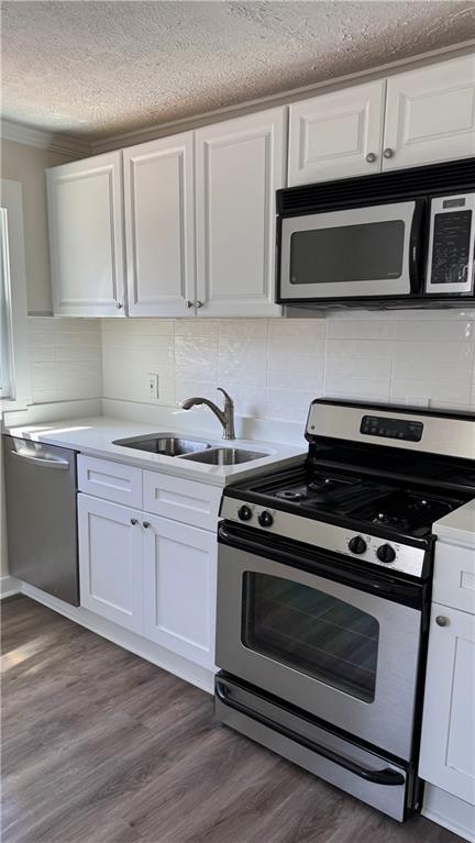 kitchen with a sink, white cabinets, and stainless steel appliances