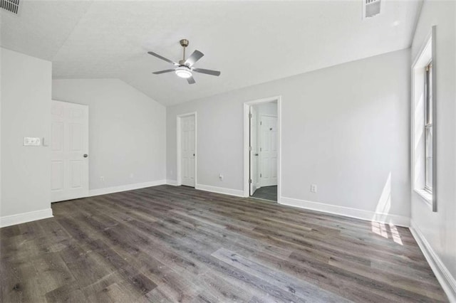 empty room with ceiling fan, vaulted ceiling, and wood-type flooring