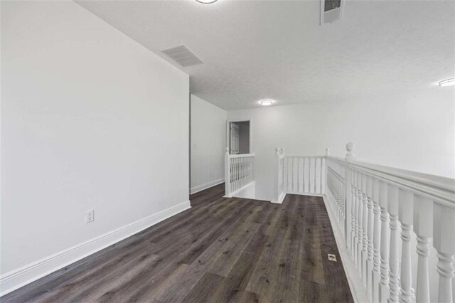 empty room with dark hardwood / wood-style flooring