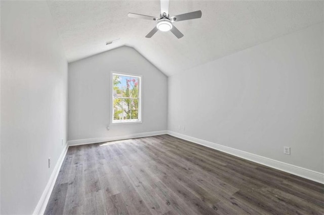 additional living space with ceiling fan, vaulted ceiling, wood-type flooring, and a textured ceiling