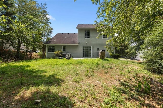 rear view of property with a lawn