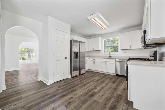 kitchen featuring white cabinetry, plenty of natural light, appliances with stainless steel finishes, and dark hardwood / wood-style floors