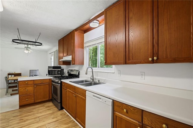 4051 Dixie Ln, Douglasville, GA 30135 - kitchen featuring white dishwasher, stainless steel gas range oven, a ceiling fan, a peninsula, and under cabinet range hood