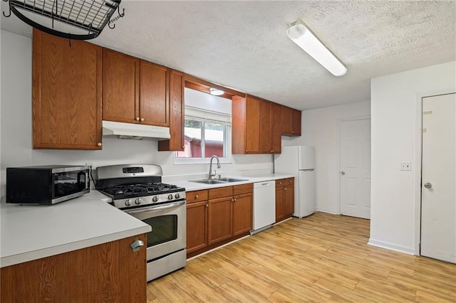 4051 Dixie Ln, Douglasville, GA 30135 - kitchen featuring white appliances, under cabinet range hood, light wood-style floors, light countertops, and brown cabinets