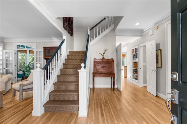 entrance foyer featuring ornamental molding and light wood-type flooring