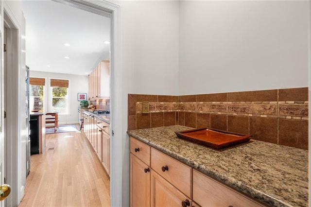 interior space with tasteful backsplash and hardwood / wood-style flooring