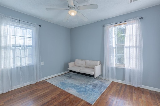 unfurnished room with ceiling fan, dark hardwood / wood-style flooring, and a textured ceiling