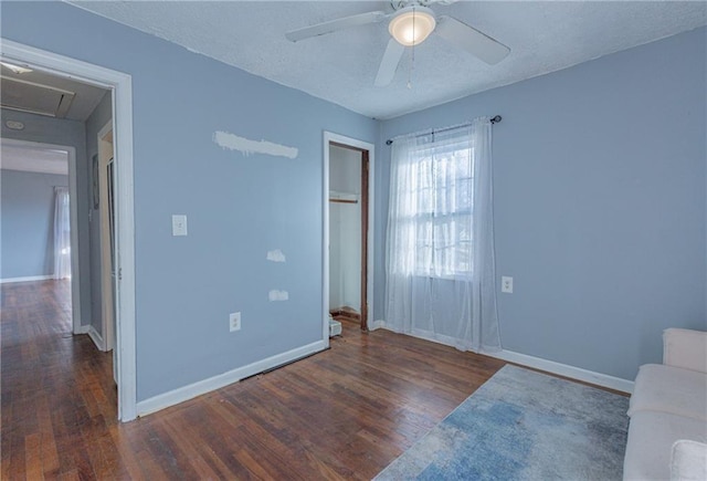 unfurnished bedroom featuring a textured ceiling, ceiling fan, dark wood-type flooring, and a closet