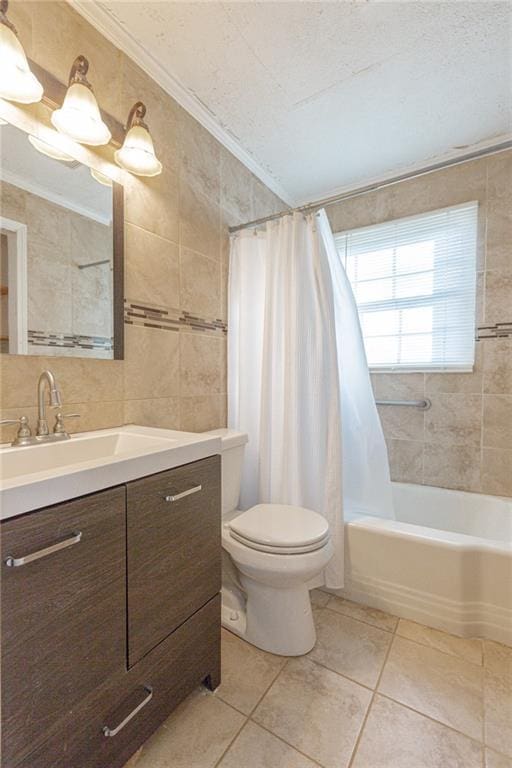 full bathroom with tile patterned floors, a textured ceiling, shower / tub combo with curtain, and tile walls