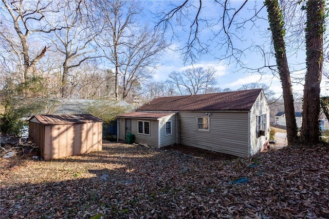 back of property with a storage shed