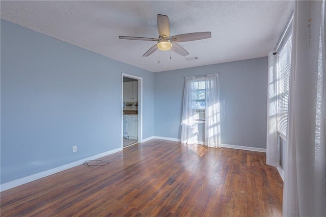 unfurnished room featuring a textured ceiling, ceiling fan, and dark hardwood / wood-style floors