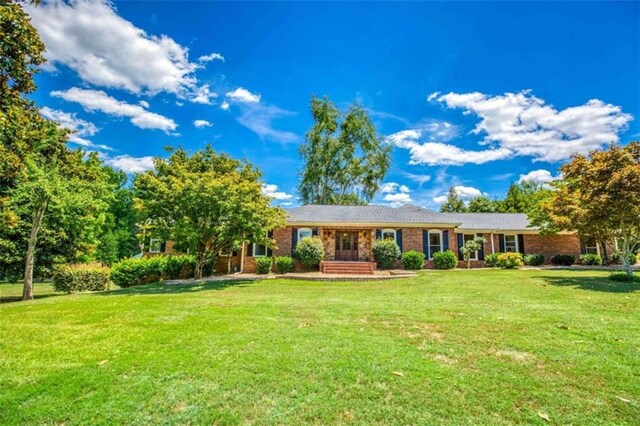 rear view of house with a lawn and a patio