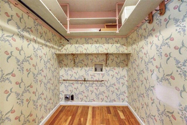 unfurnished living room with ceiling fan, ornamental molding, a brick fireplace, and light wood-type flooring