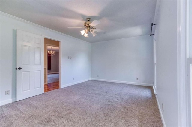 carpeted spare room featuring crown molding and ceiling fan with notable chandelier