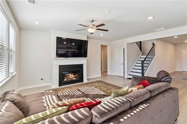 living room featuring a wealth of natural light, ceiling fan, and light hardwood / wood-style floors