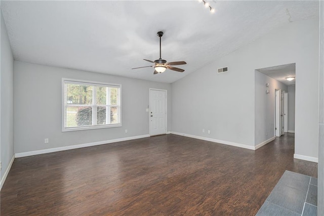 unfurnished living room with visible vents, dark wood finished floors, baseboards, ceiling fan, and vaulted ceiling