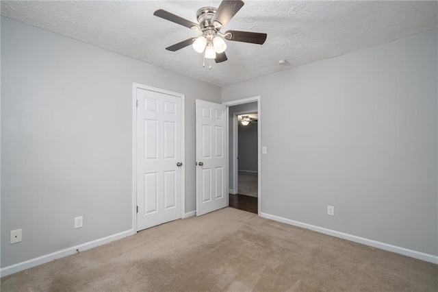 unfurnished bedroom featuring baseboards, a textured ceiling, ceiling fan, and carpet flooring