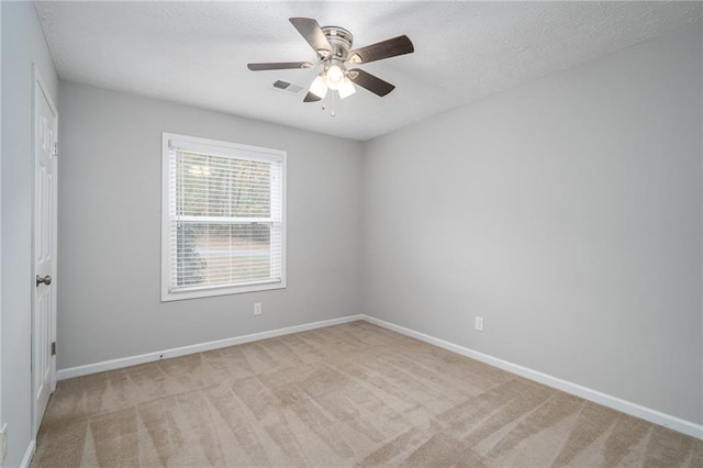 empty room featuring baseboards, light carpet, and a textured ceiling