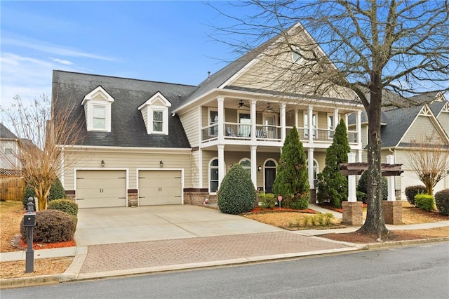 view of front of house featuring a balcony, driveway, and ceiling fan