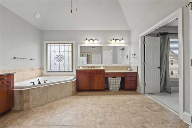 bathroom featuring lofted ceiling, a bath, and vanity