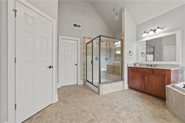 bathroom featuring visible vents, a stall shower, tiled bath, lofted ceiling, and vanity