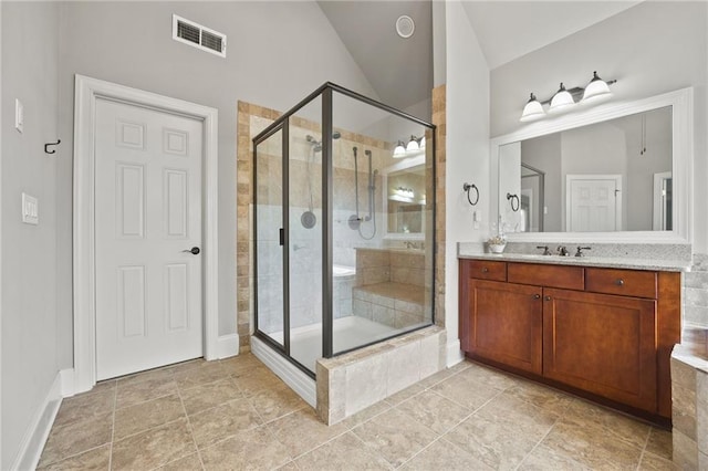 full bath with vanity, a shower stall, visible vents, and lofted ceiling