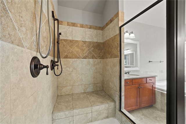 bathroom featuring tiled shower, tiled tub, and vanity