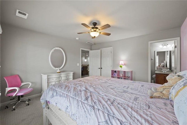 bedroom with visible vents, baseboards, carpet, ensuite bathroom, and a ceiling fan