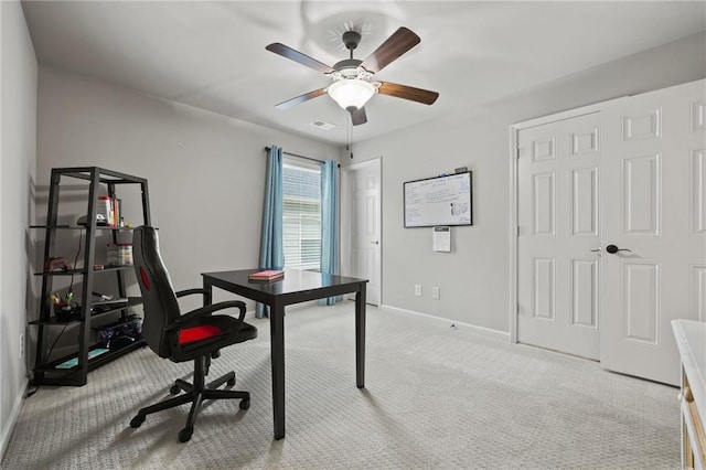 carpeted office space featuring visible vents, a ceiling fan, and baseboards