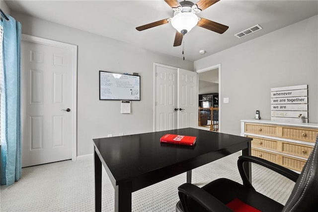 office space with visible vents, light colored carpet, and ceiling fan