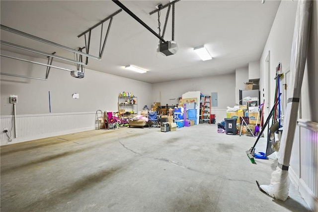 garage with electric panel and a garage door opener