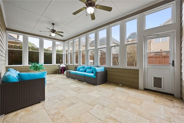 sunroom / solarium featuring a ceiling fan