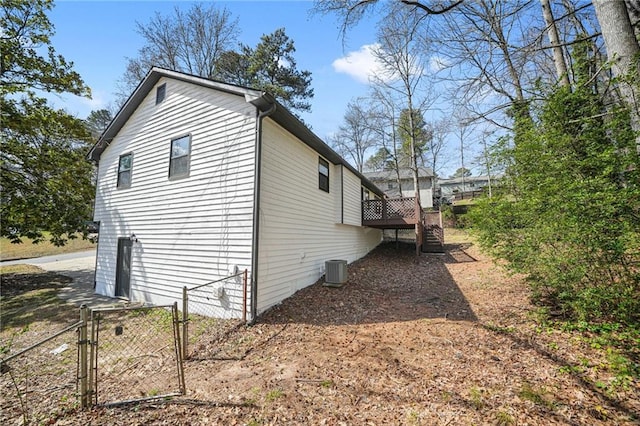 view of side of property featuring a gate, a deck, fence, stairway, and cooling unit