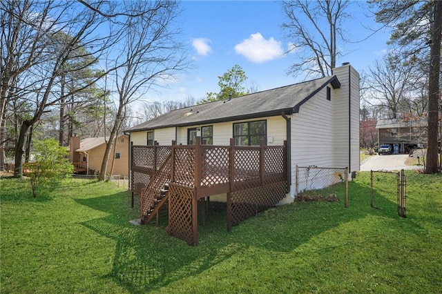 back of house featuring a chimney, a deck, a yard, and fence