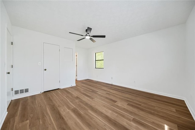 unfurnished bedroom with baseboards, visible vents, a ceiling fan, and wood finished floors