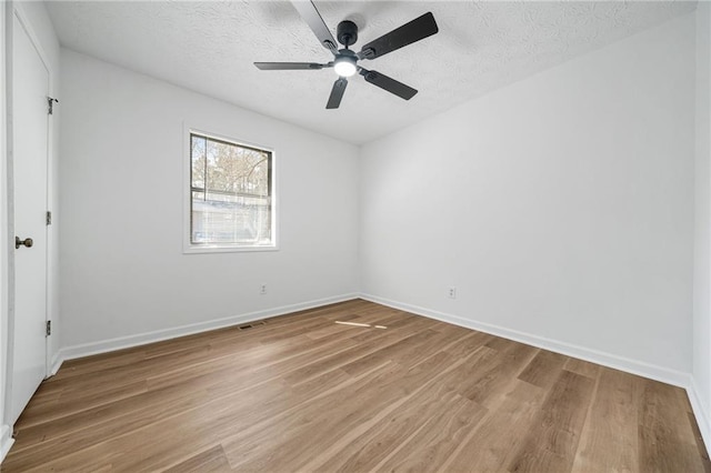 unfurnished bedroom featuring ceiling fan, a textured ceiling, baseboards, and light wood-type flooring