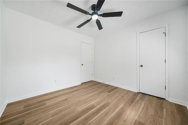 unfurnished bedroom featuring baseboards, a ceiling fan, and wood finished floors