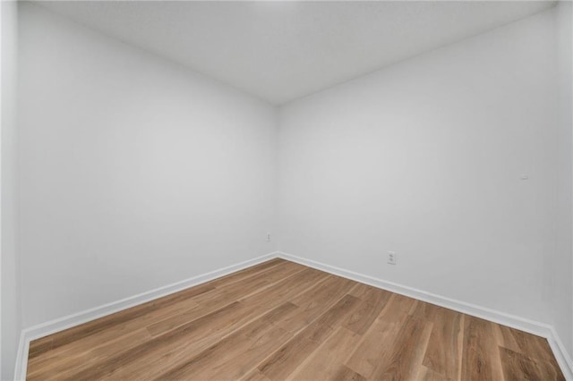 unfurnished room with baseboards and wood finished floors
